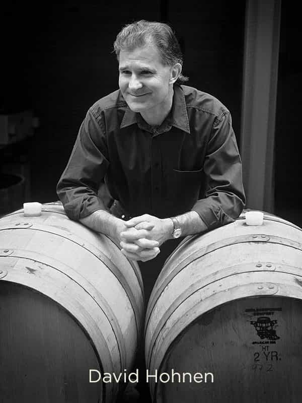 Cloudy Bay founder David Hohnen leaning on wine barrels